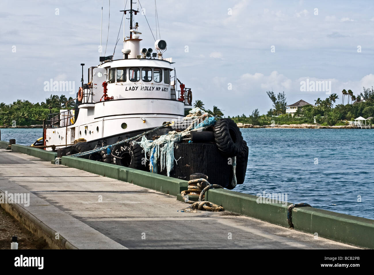 Tugboat by a dock on a tranquil sea in Nassau, Bahamas Stock Photo