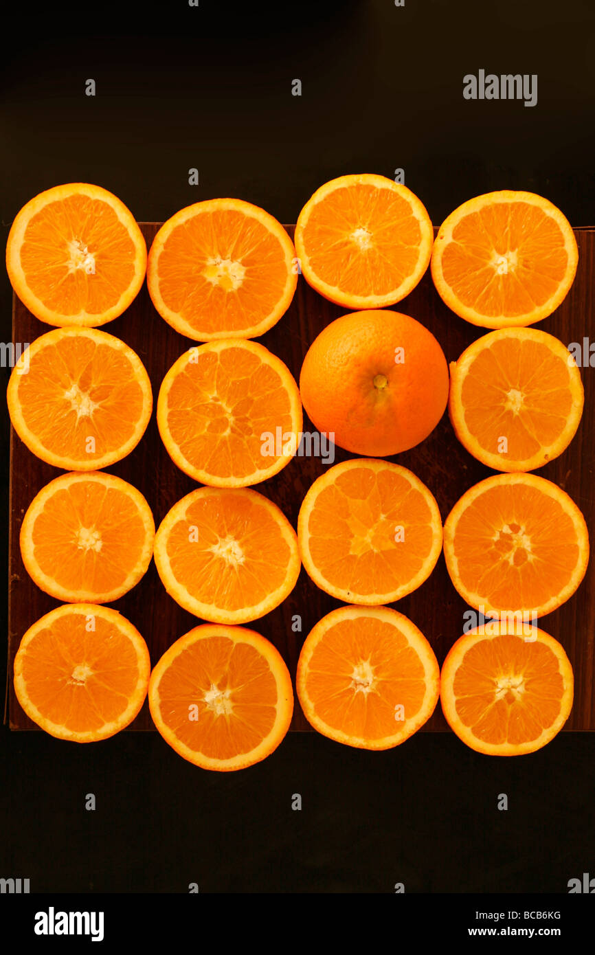 The Orange fruit laid out in a pattern with some cut in half Stock Photo