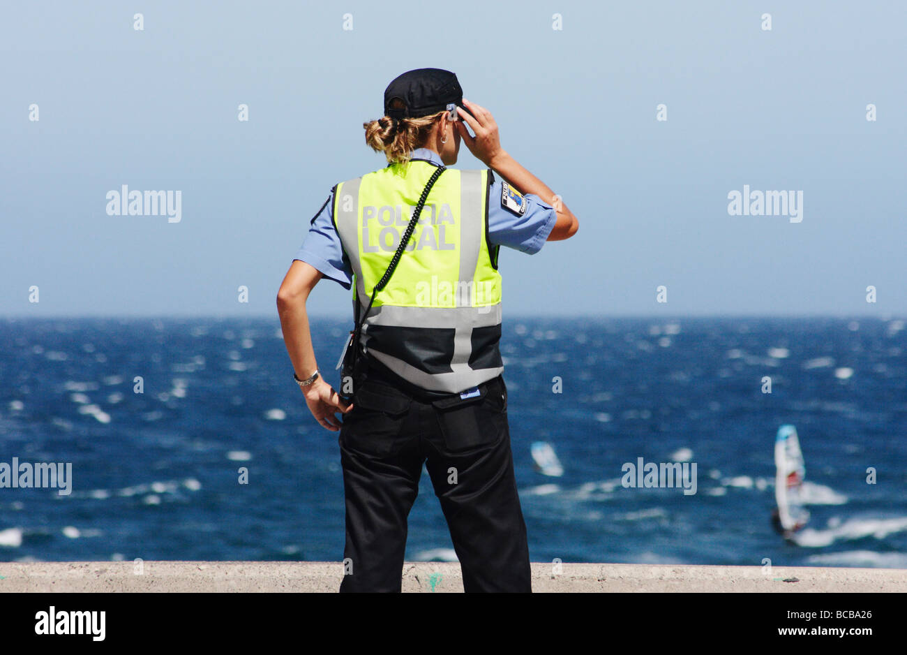 Policia Local (local police) policewoman looking out to sea at Pozo on Gran Canaria in The Canary Islands, Spain Stock Photo