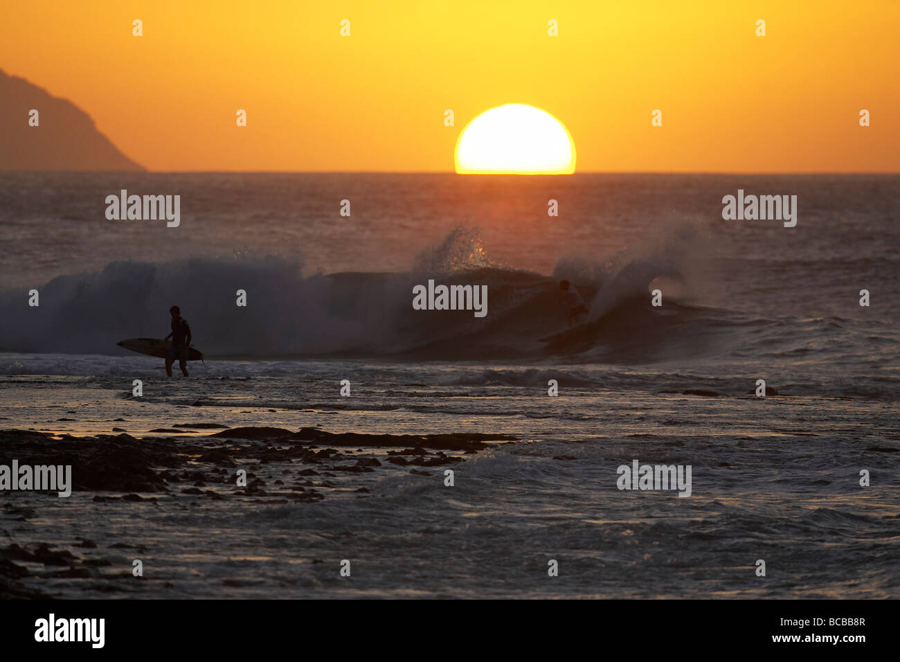 Sun setting over ocean Stock Photo