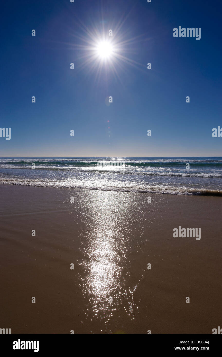 Sun shining in blue sky over beach Stock Photo
