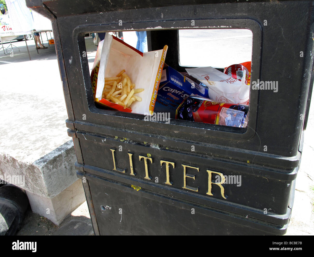 A Litter bin with jun food placed in it such as French Fries Stock Photo