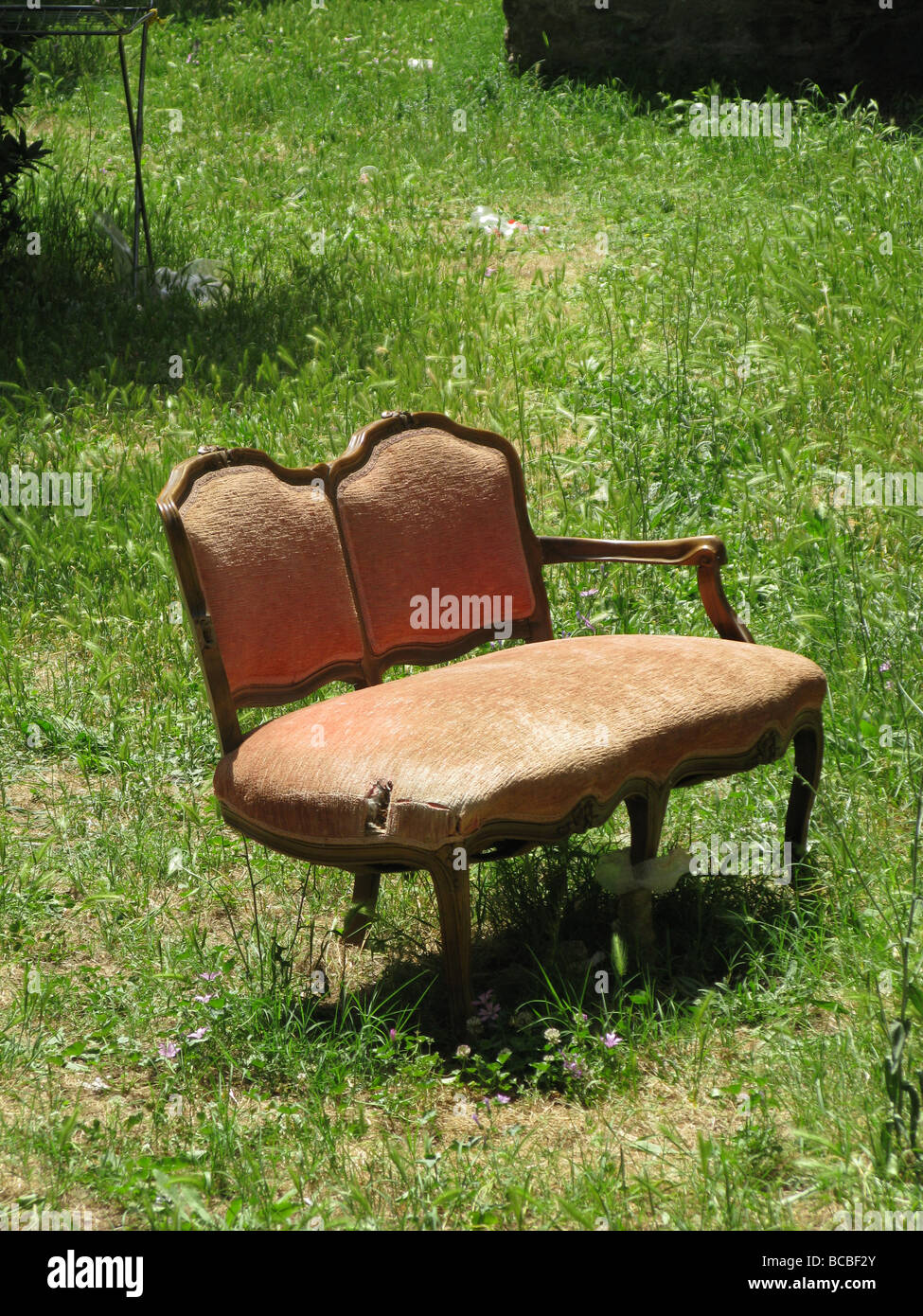 one old damaged sofa dumped in field in countryside Stock Photo Alamy