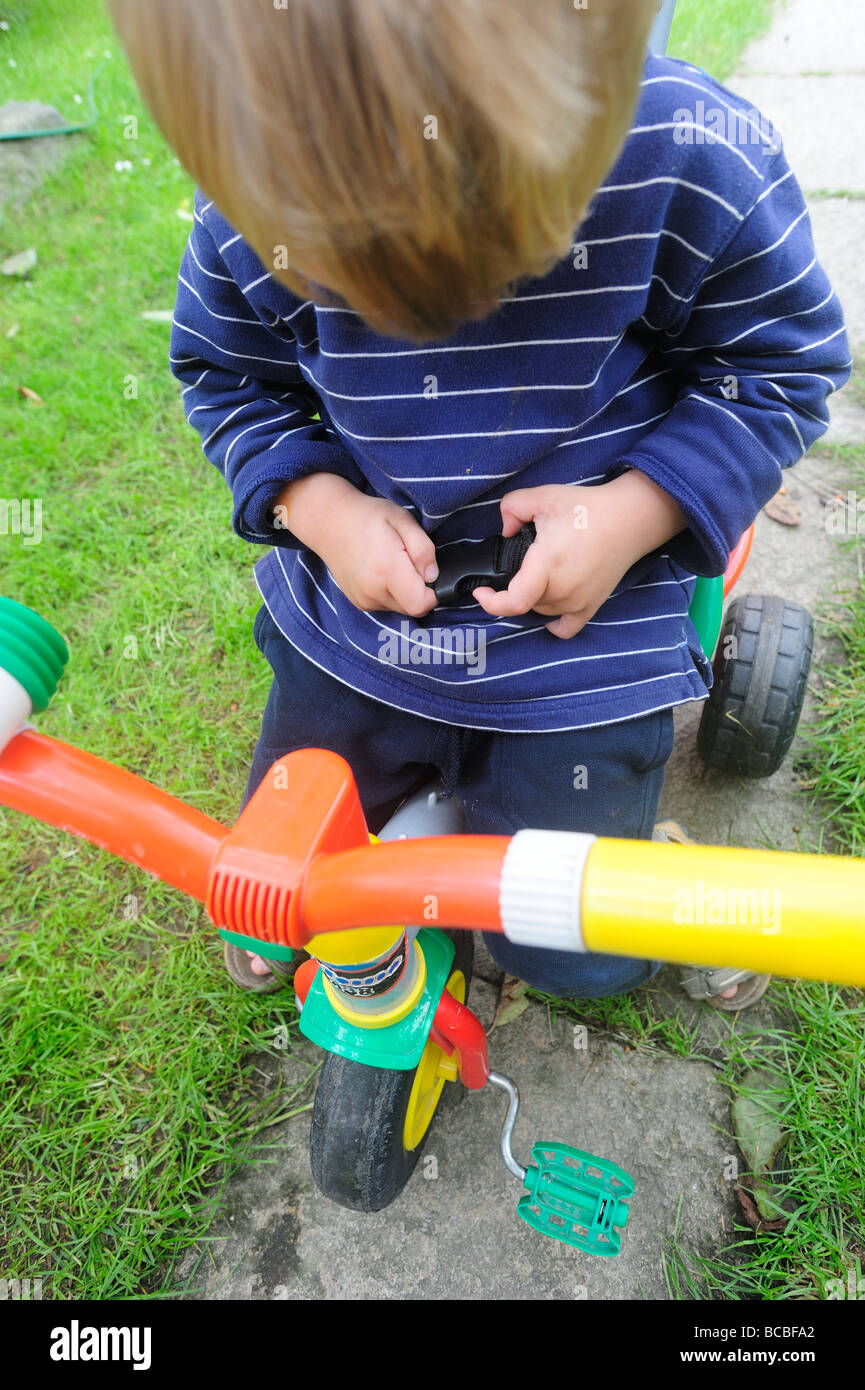 Three year old blond boy riding tricycle Stock Photo Alamy