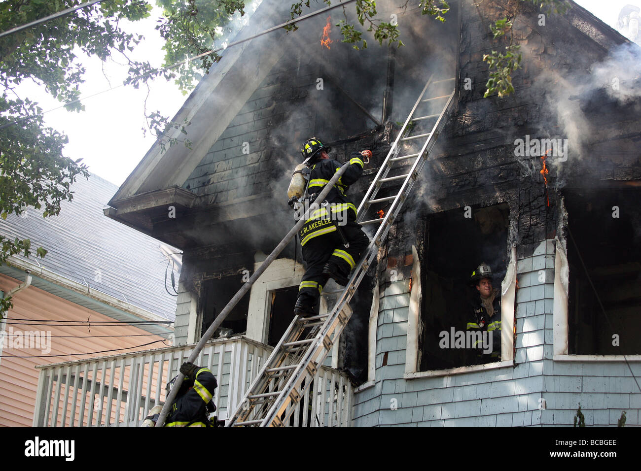 Firefighters climb a ladder during a battle a two alarm blaze in New Haven Connecticut USA Stock Photo