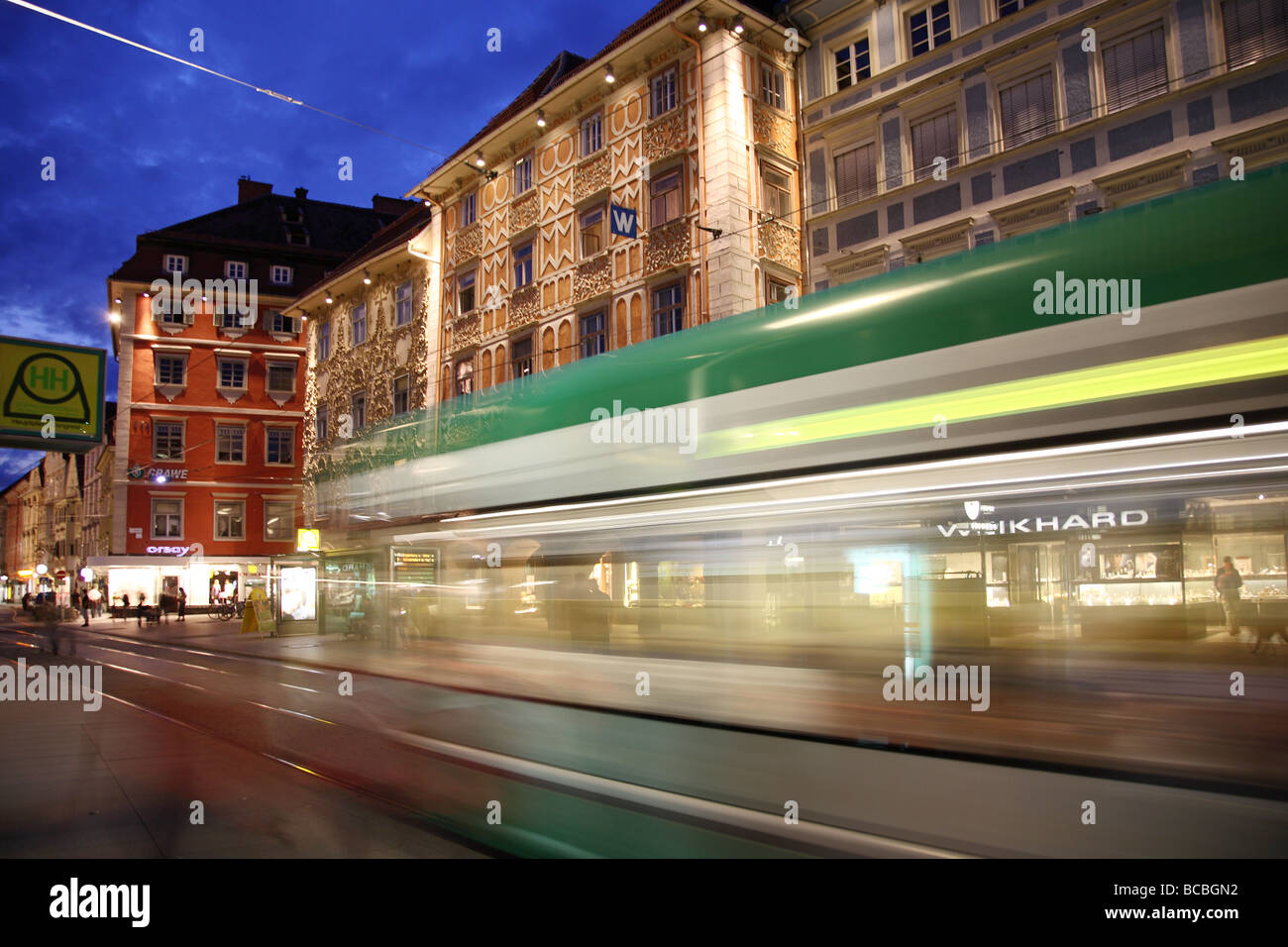 Ornate building facades and a motion blurredTram in the old precinct of Graz Stock Photo