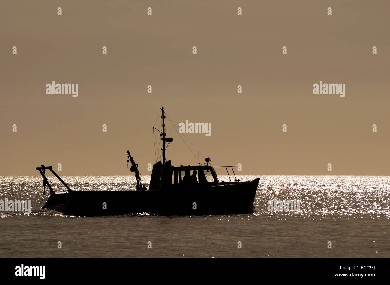 A silhouette of a small fishing boat Stock Photo - Alamy