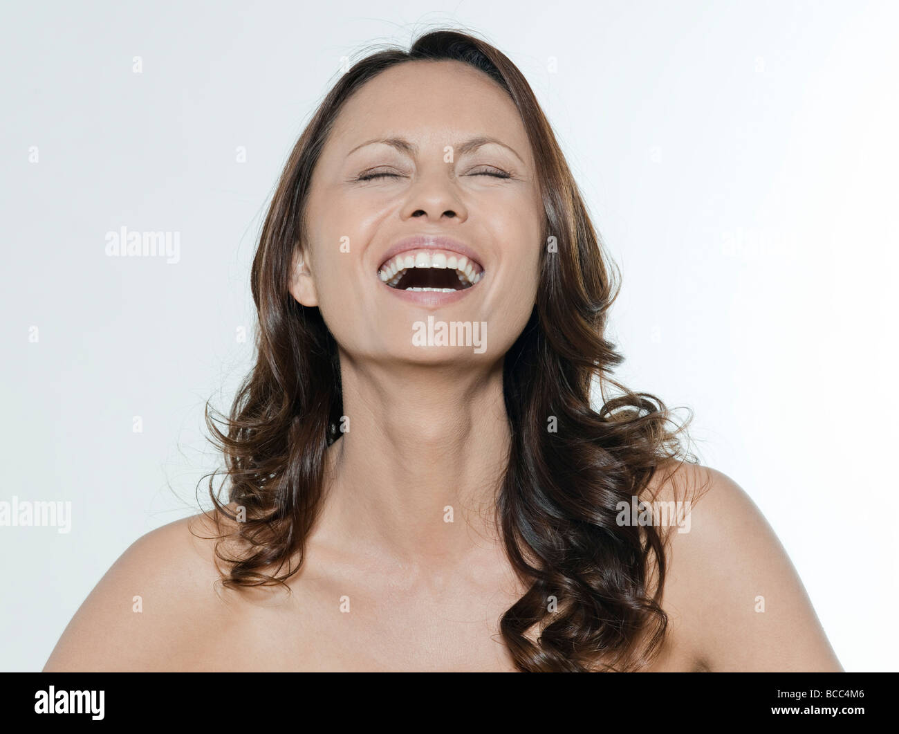 Portrait of beautiful Asian happy woman laughing with eyes closed in ...
