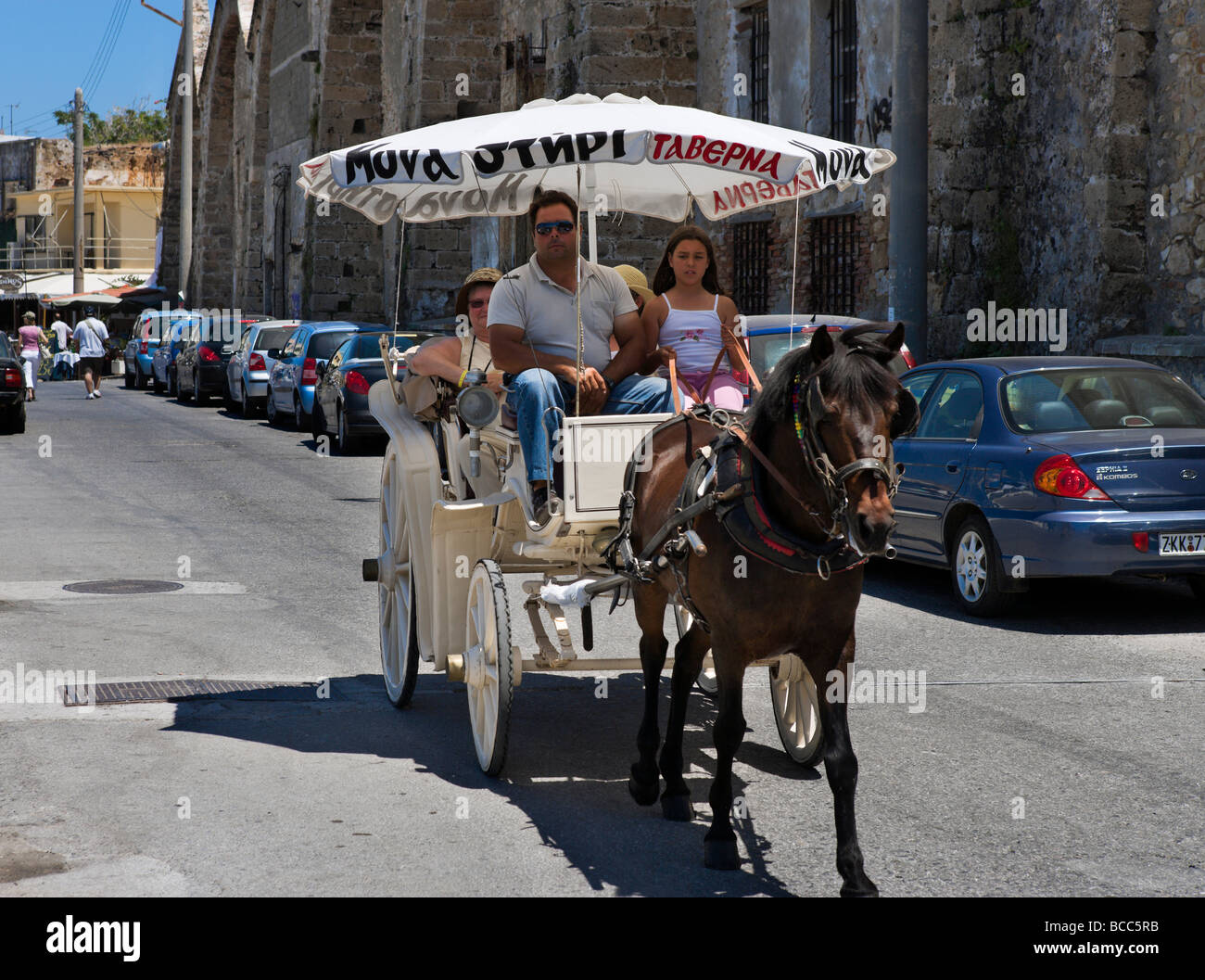 Horse drawn carriage ride in front of the historic Shipyards in the Old Venetian Harbour, Chania, Crete, Greece Stock Photo