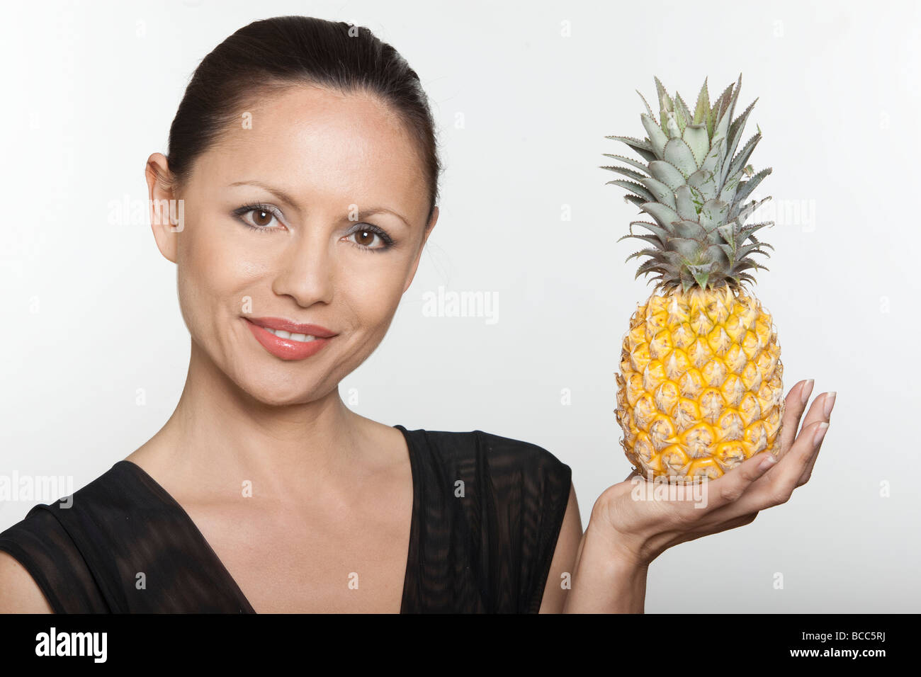 woman holding pineapple juice fruit studio Stock Photo Alamy