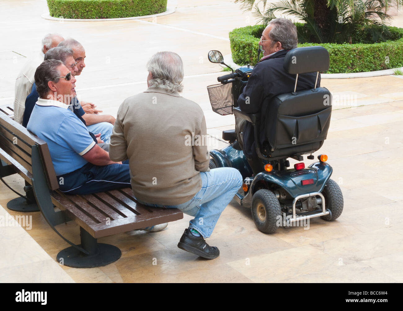 Marbella Spain Old timers chatting in a plaza Stock Photo