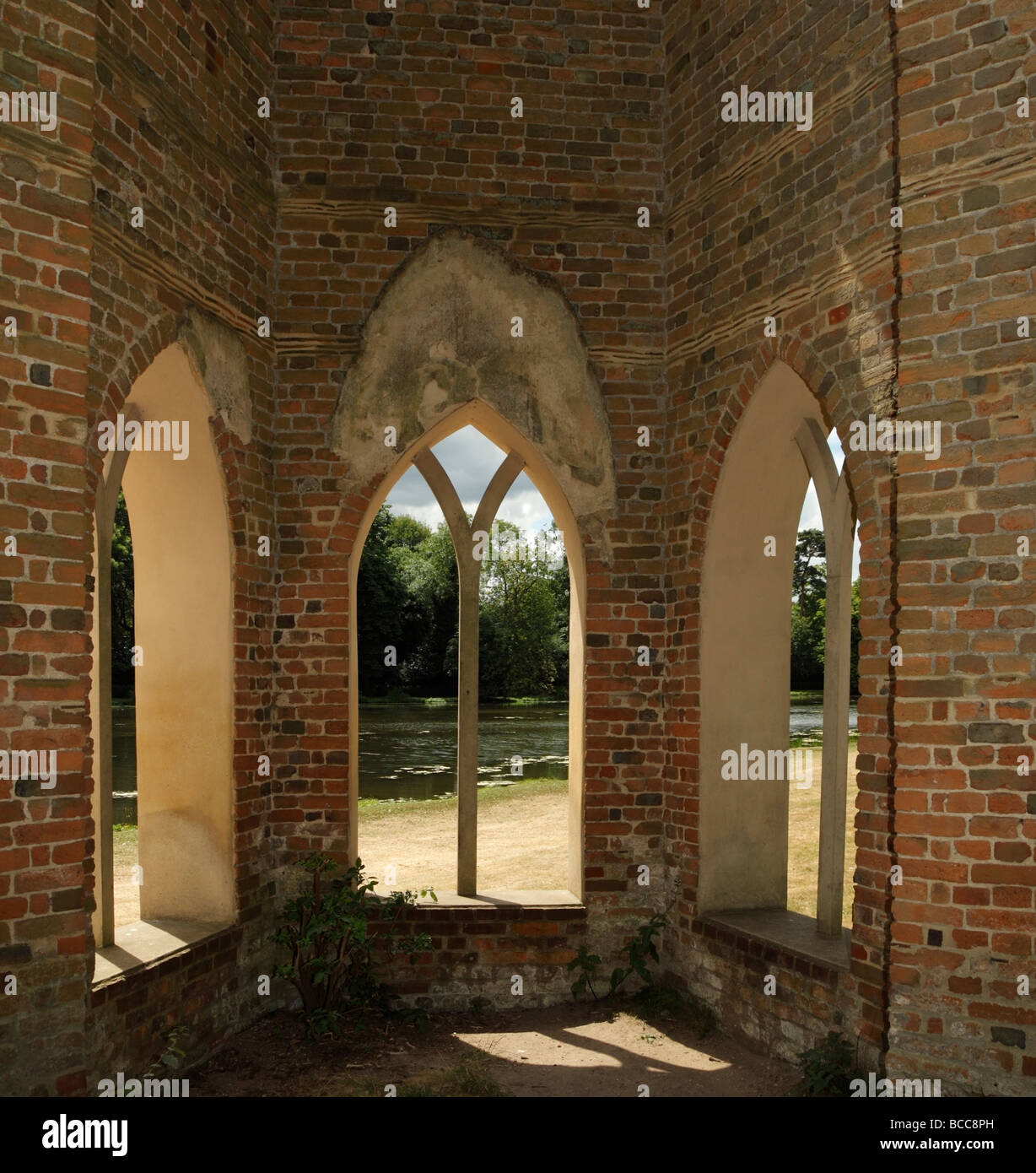 Gothic arched windows with a view onto a lake. Stock Photo