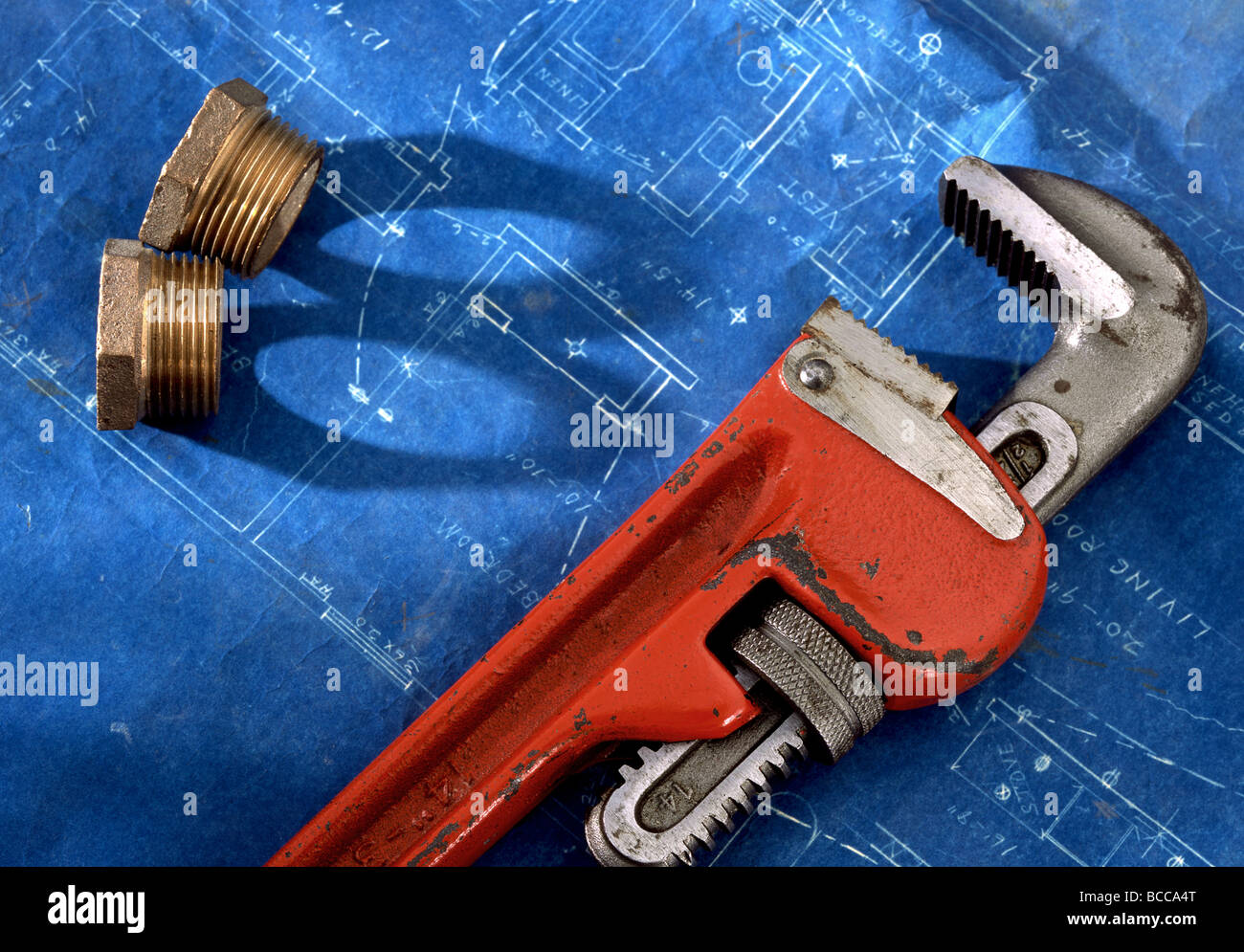Pipe wrench and pipe coupling on a blueprint Stock Photo Alamy