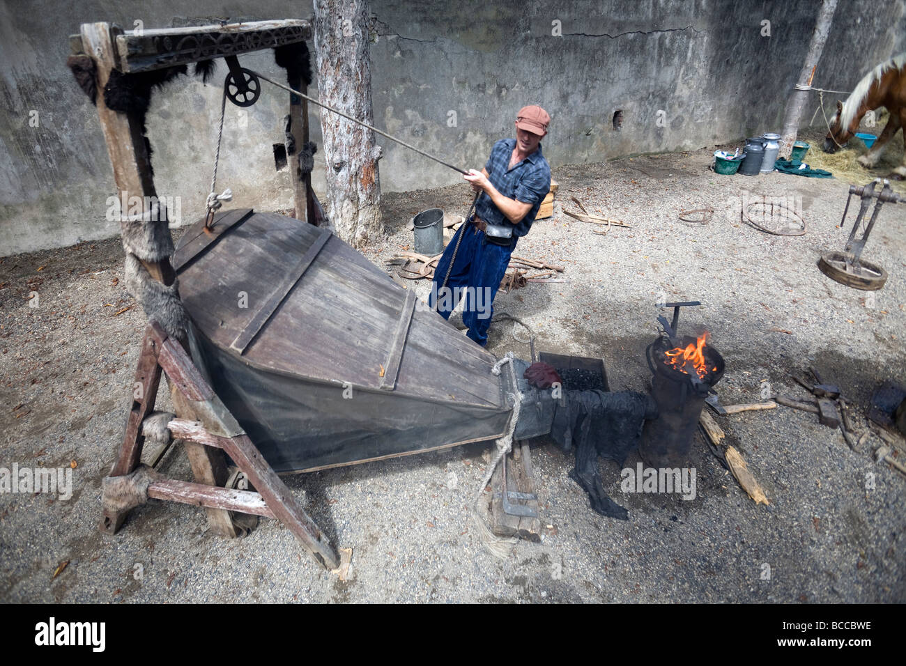 A blacksmith operating his bellows. Forgeron actionnant son soufflet de forge. Stock Photo