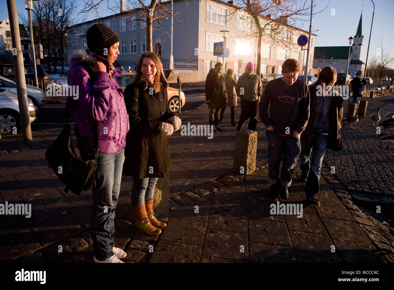 Two girls talking and smiling on a sunny autumn afternoon Downtown Reykjavik Iceland Stock Photo