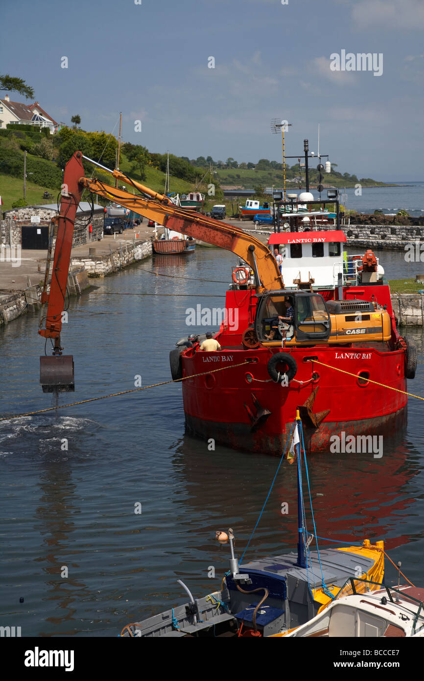 ship containing earth mover dredging carnlough harbour county antrim northern ireland uk Stock Photo