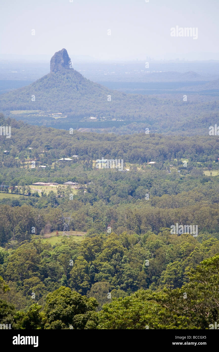 View past the Glass House Mountain s peak of Coonowrin to the Brisbane skyline Stock Photo