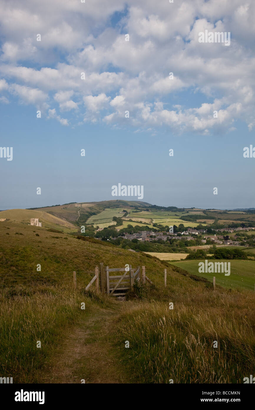 Corfe Castle ruins and village and Purbeck Hills as seen from the footpath, Dorset, England Stock Photo