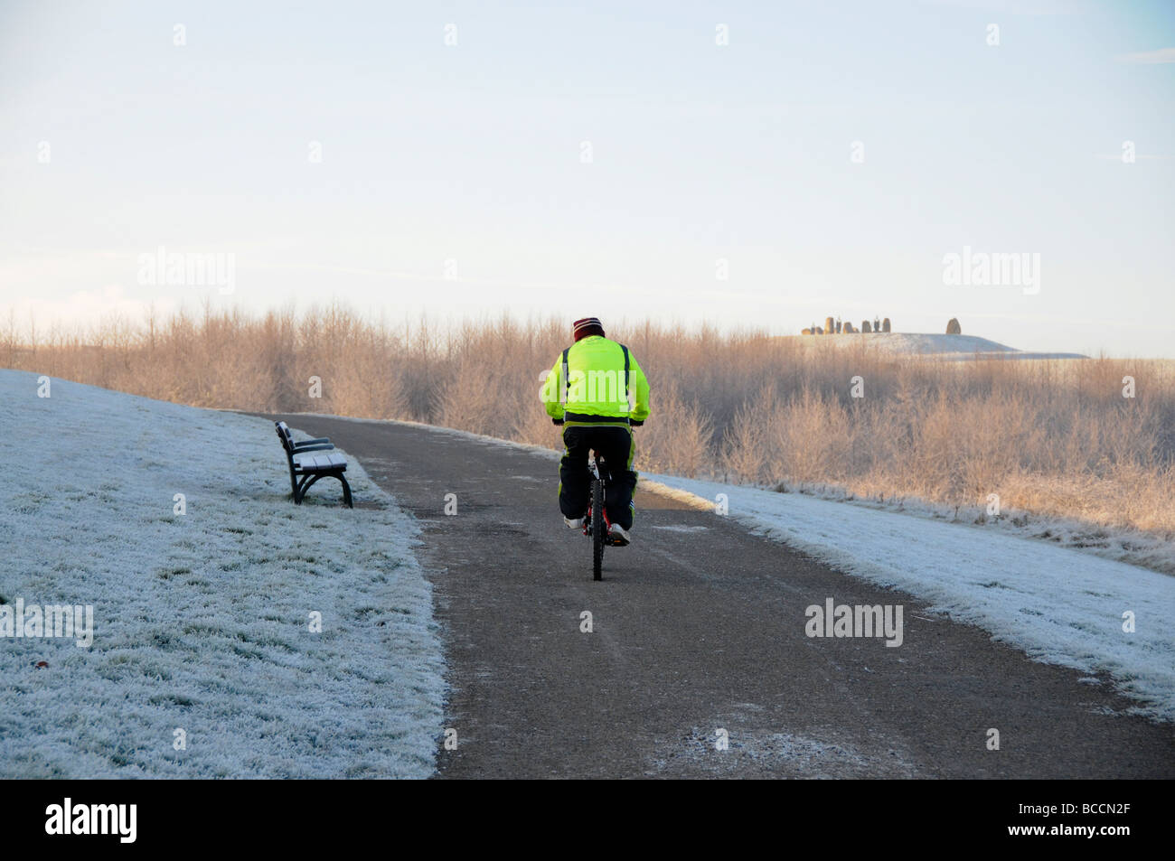 Cyclist riding bike on snow covered road in Herrington Country Park