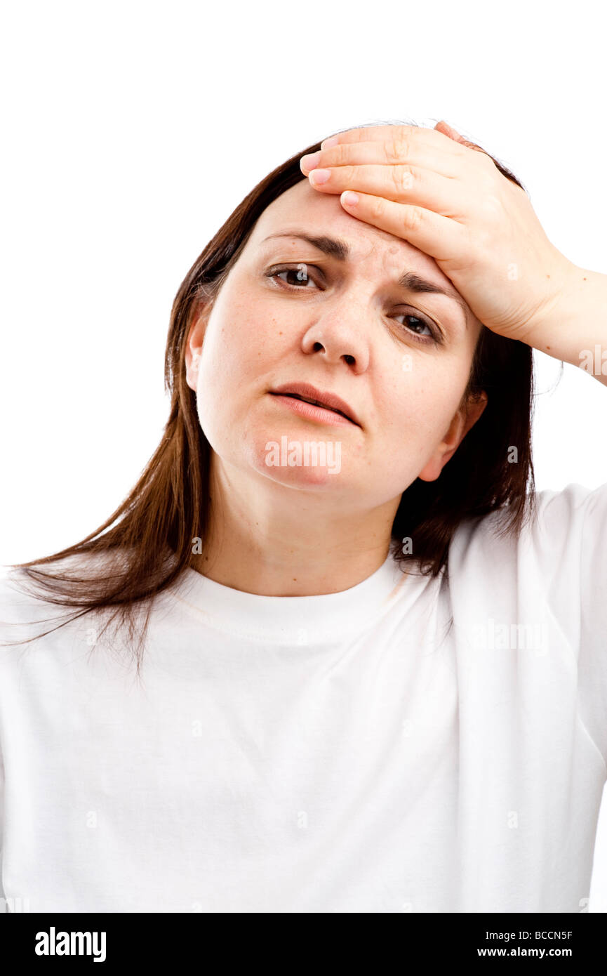 a woman holding her hand on her forehead feeling ill with a headache hangover having overindulged suffering morning after Stock Photo