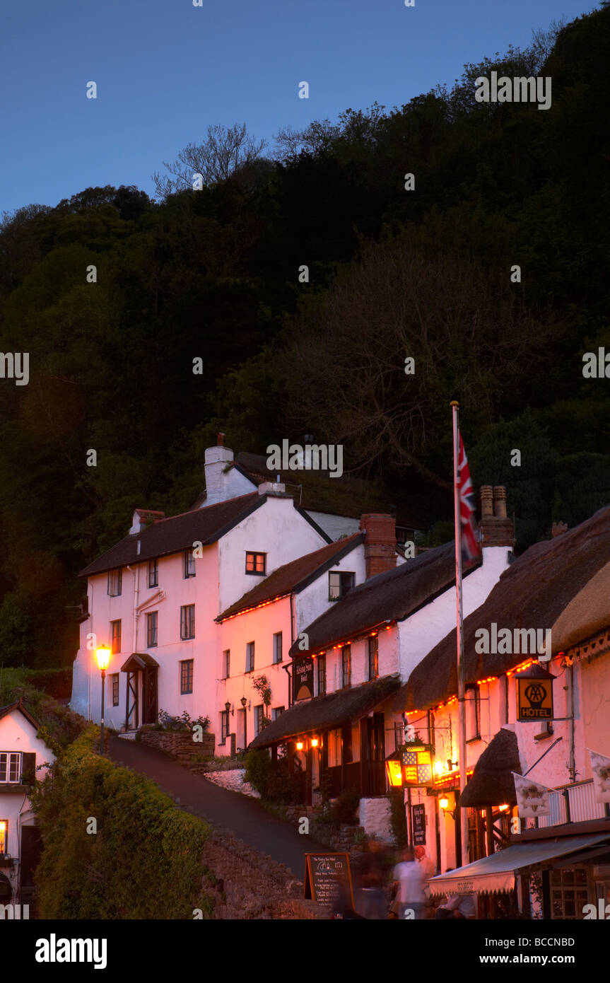 The Rising Sun hotel lit by street lamps at dusk on the steep path leading up from Lynmouth harbour North Devon UK Stock Photo