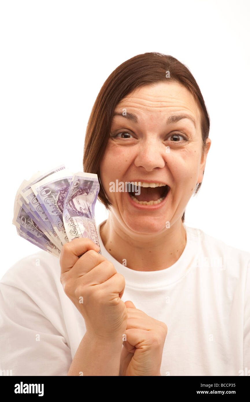 a happy laughing young woman holding  a hand full of 20 notes cash wages UK Stock Photo