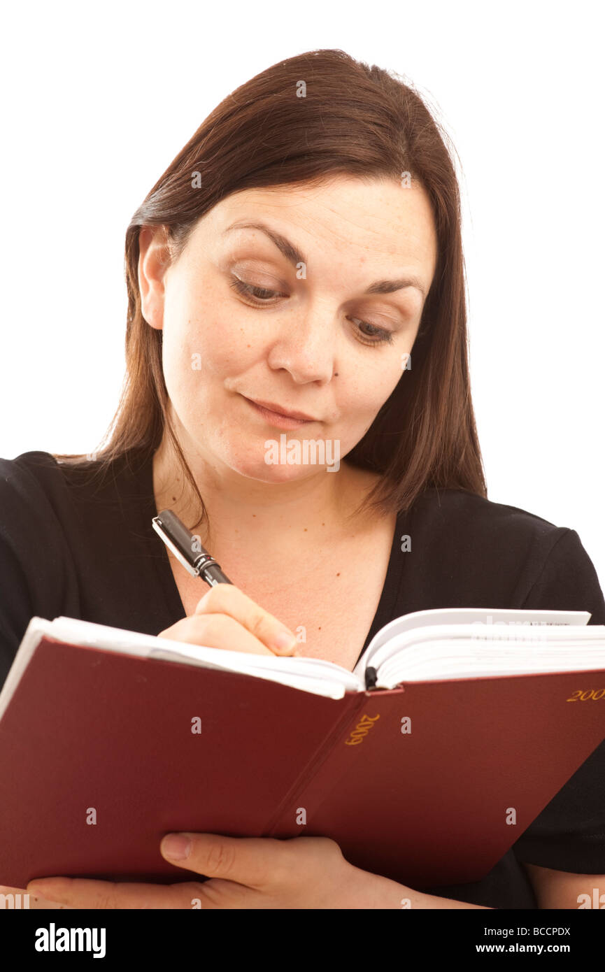 A 30 year old young woman writing in her daily diary journal notebook Stock Photo