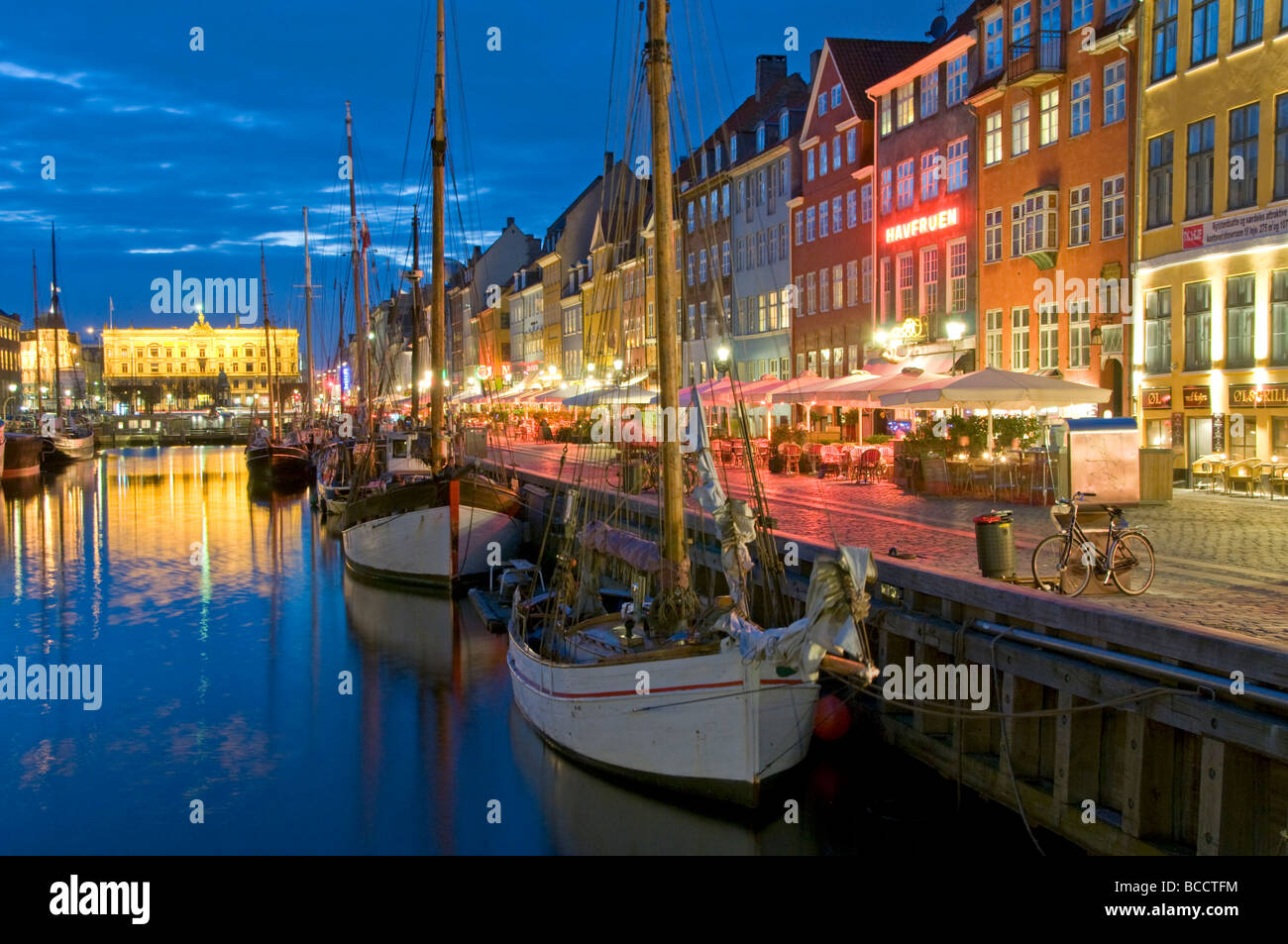 Historic Old Boats Moored Alongside Nyhavn Quayside at Night, Nyhavn, Copenhagen, Denmark, Europe Stock Photo