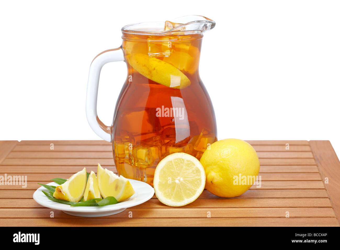 Ice tea pitcher with lemon and icecubes on wooden background Stock Photo