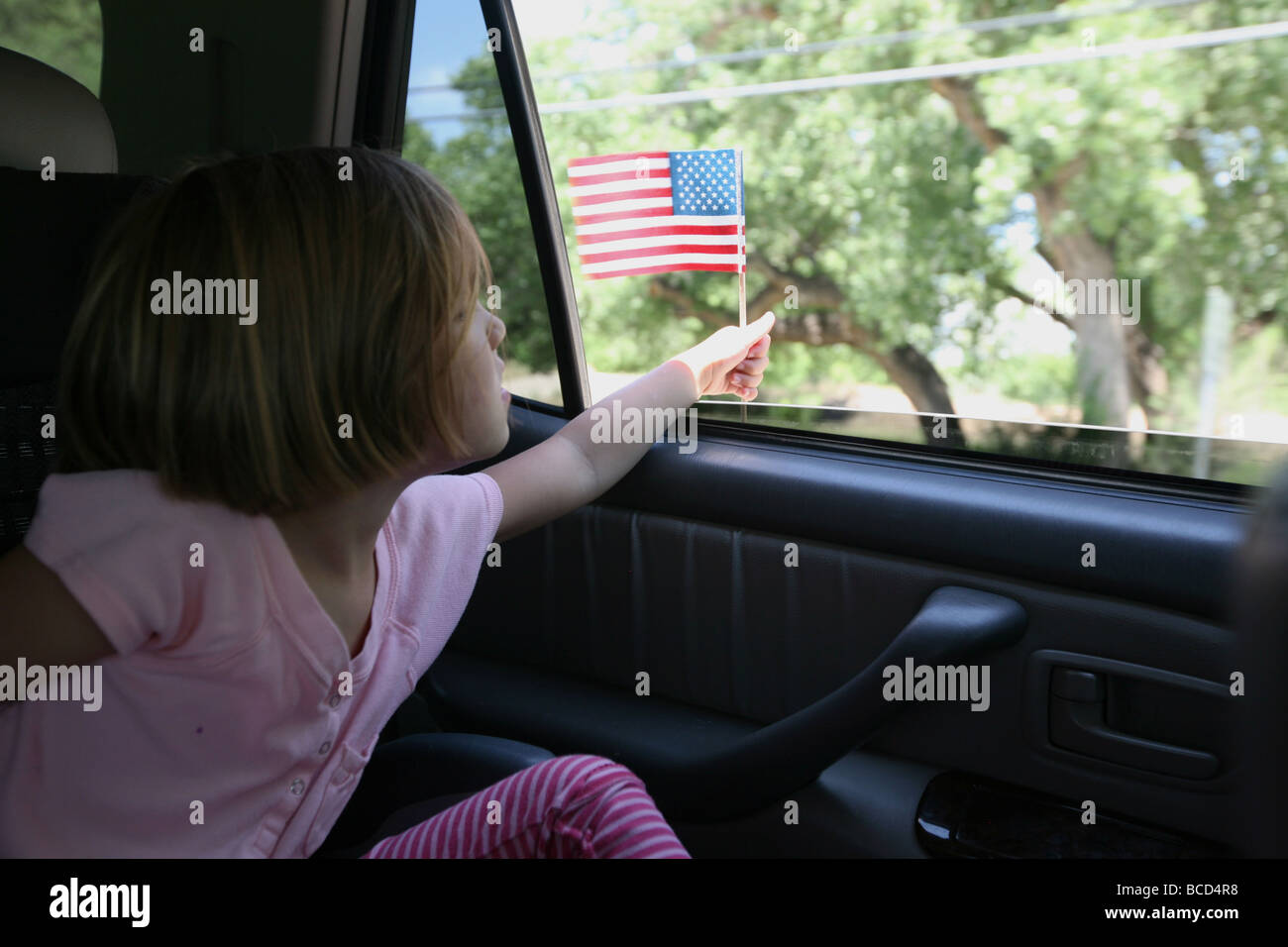 Girl holding american flag at parade hi-res stock photography and ...