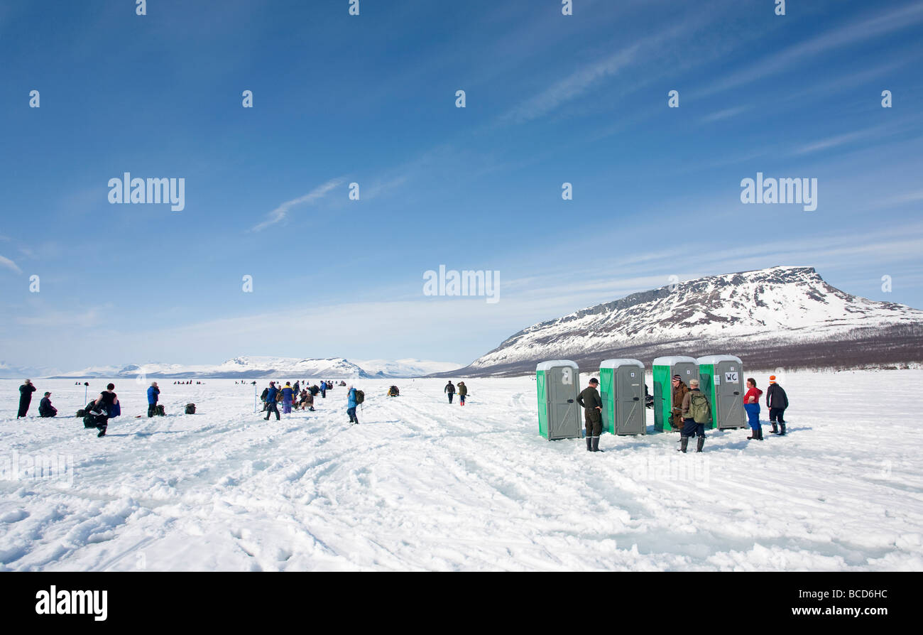 People queuing to arctic outhouses at Lake Kilpisjärvi ice during an ice-fishing competition Saana Fjell  , Finland Stock Photo