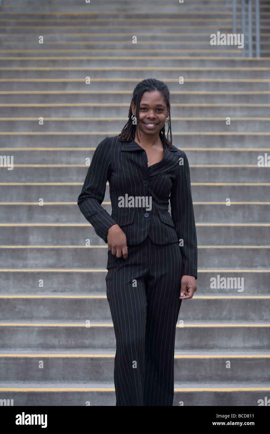 Smiling business woman walking down stairs Stock Photo - Alamy