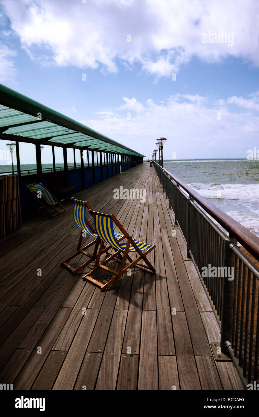 Boscombe Pier Bournemouth Dorset with deckchairs, decking and cloud formation looking out to sea Stock Photo