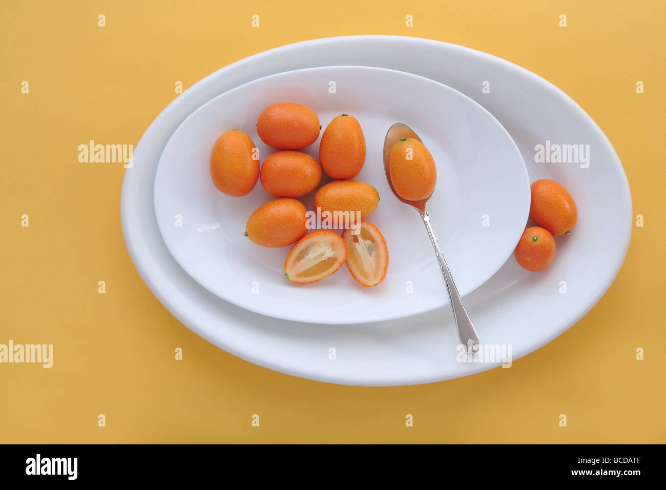 fresh kumquats on white oval dishes Stock Photo