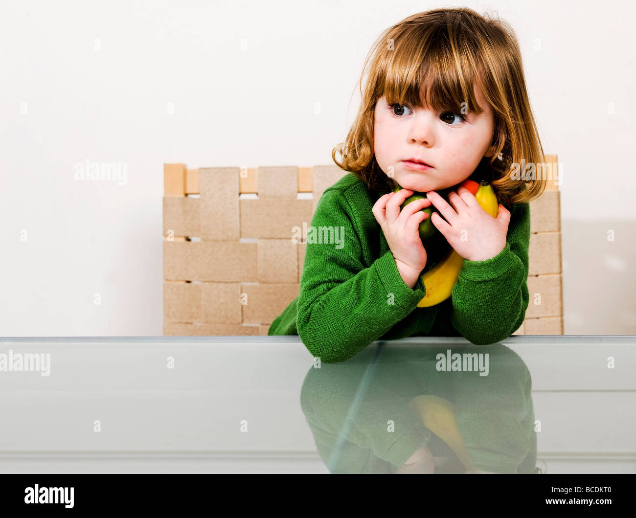 young girl with holding fruit in arms Stock Photo