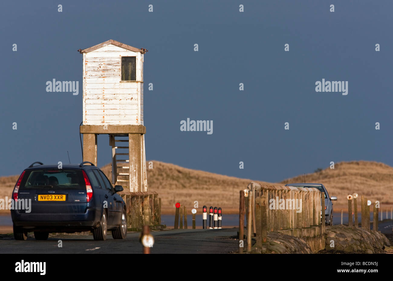 Car crossing the tidal causeway onto Holy Island Northumbria Stock Photo