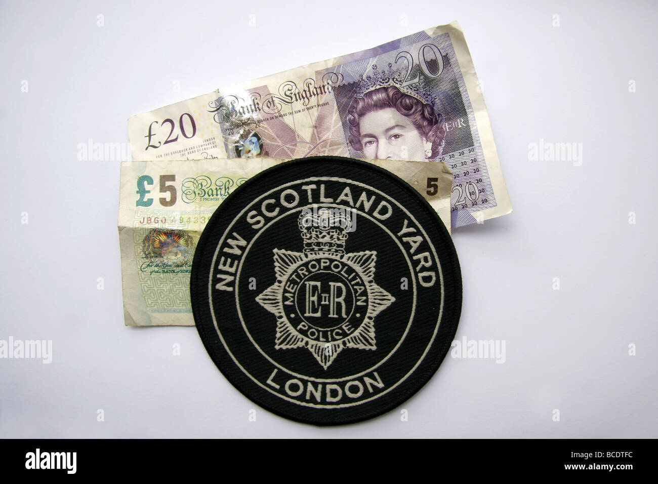 London Metropolitan Police New Scotland Yard patch and British money Stock Photo