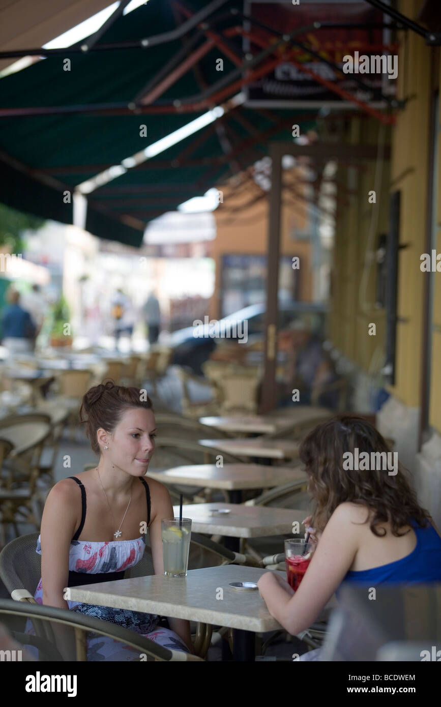 Two girls sitting outside a cafe drinking fruit cocktails Pecs Hungary - chosen as the 2010 European City of Culture Stock Photo