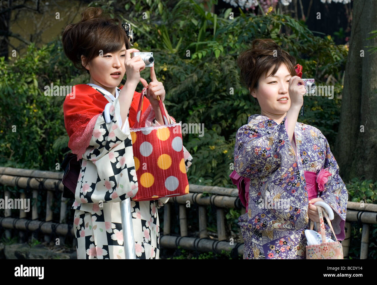 Two young women wearing kimono taking photos with their digital cameras in the Gion district of Kyoto Stock Photo
