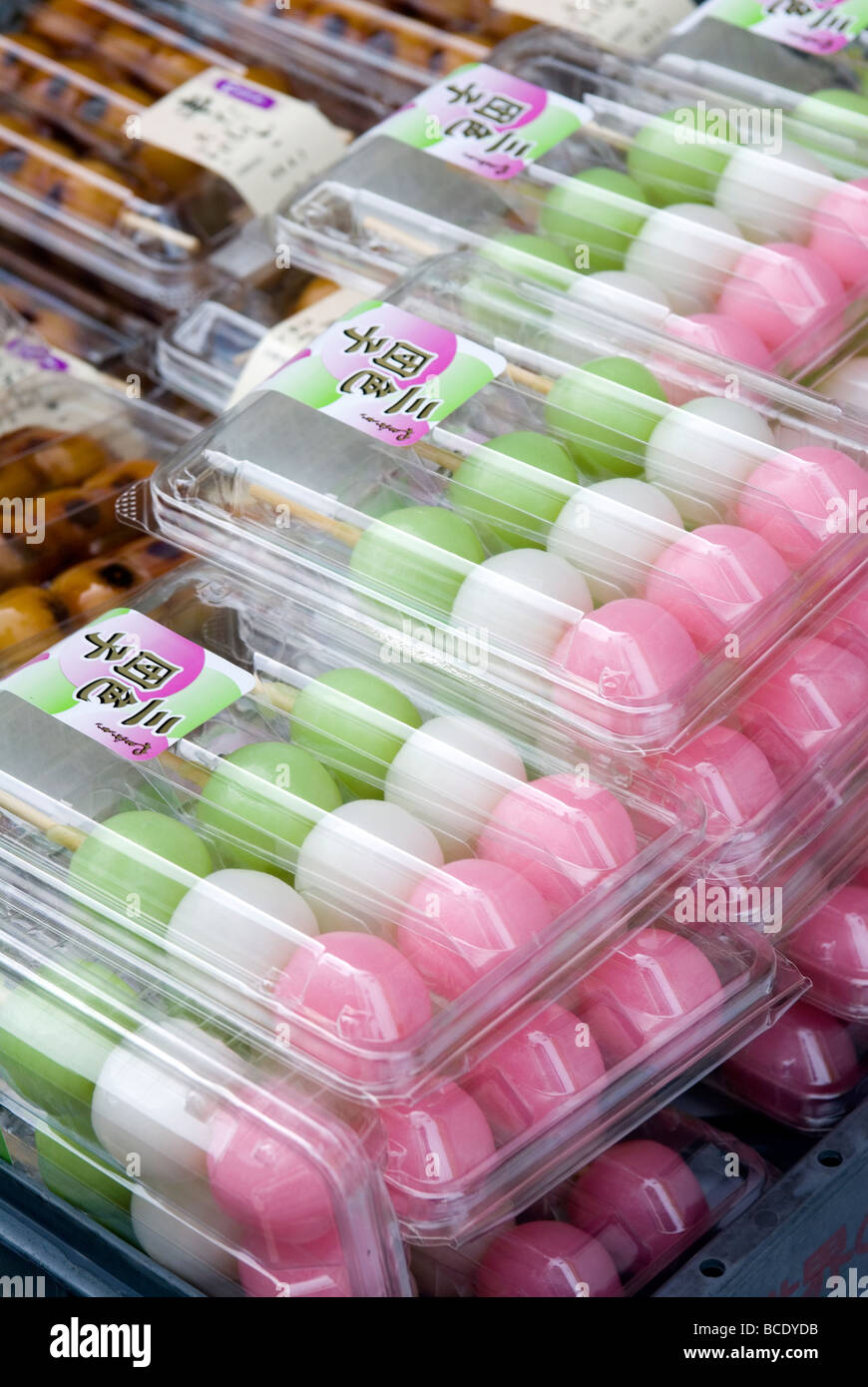 A triple colored seasonal snack of mochi balls on a stick called hanami dango is enjoyed during spring cherry blossom viewing Stock Photo