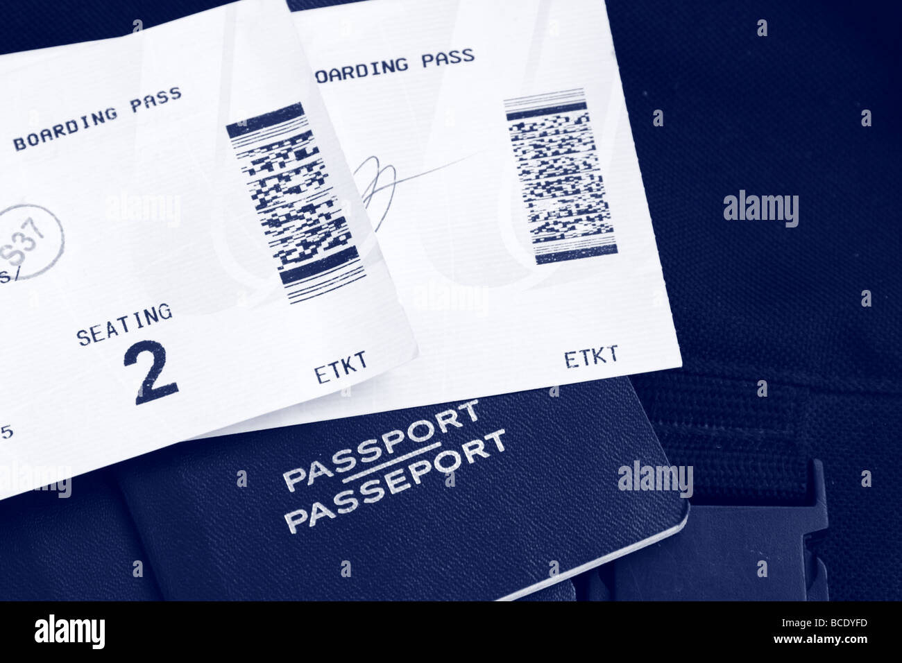 Two Boarding Passes and Canadian Passports with luggage in the background, blue tone Stock Photo