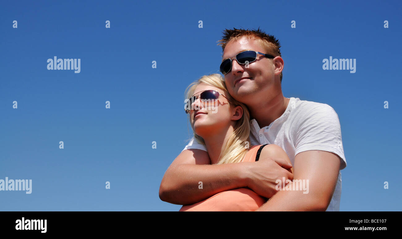 Young couple under clear blue sky Stock Photo - Alamy