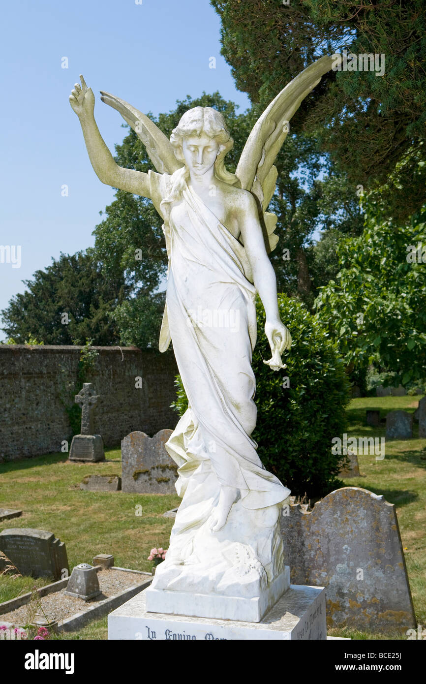 A white Angel statue over a grave in an English cemetery, West Sussex, England, UK Stock Photo