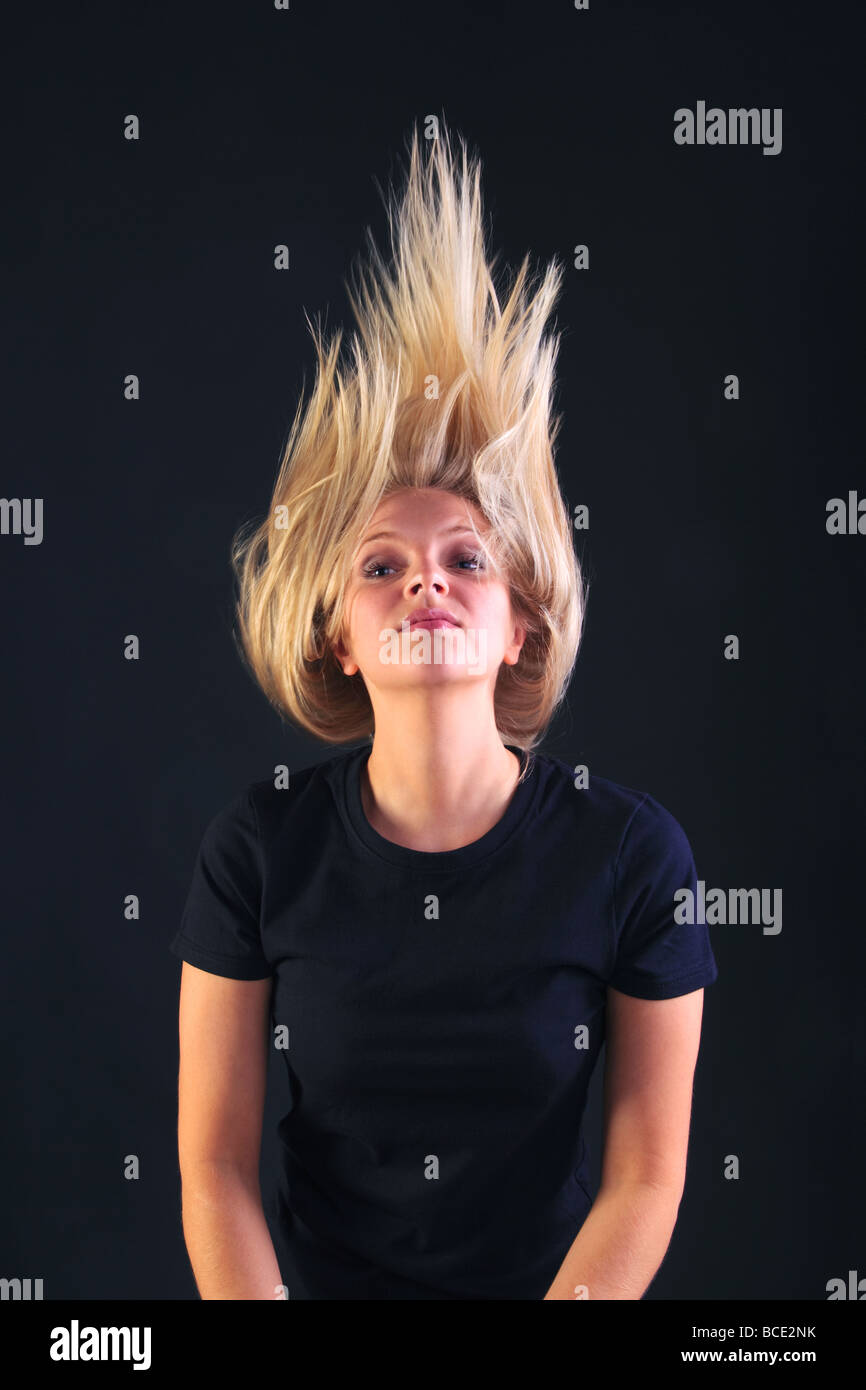 A blond woman throwing her head back letting her hair fly Stock Photo