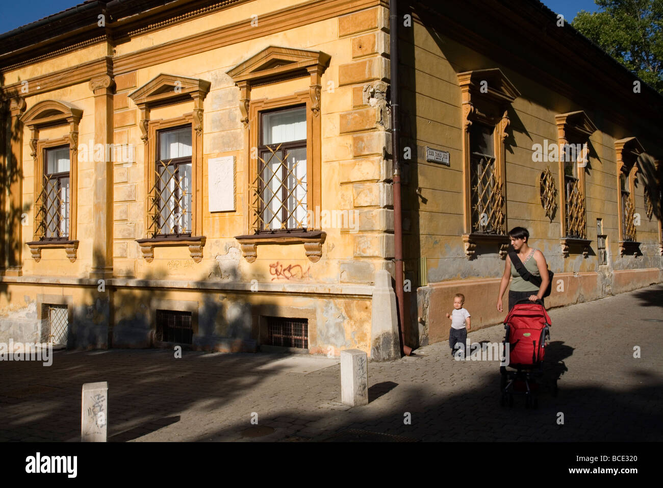 A mother and child walk past typical Nineteenth century architecture in Pecs Hungary chosen as the 2010 European City of Culture Stock Photo