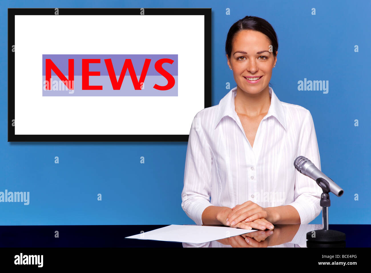 A female newsreader presenting the news add your own text or image to the screen behind her Stock Photo