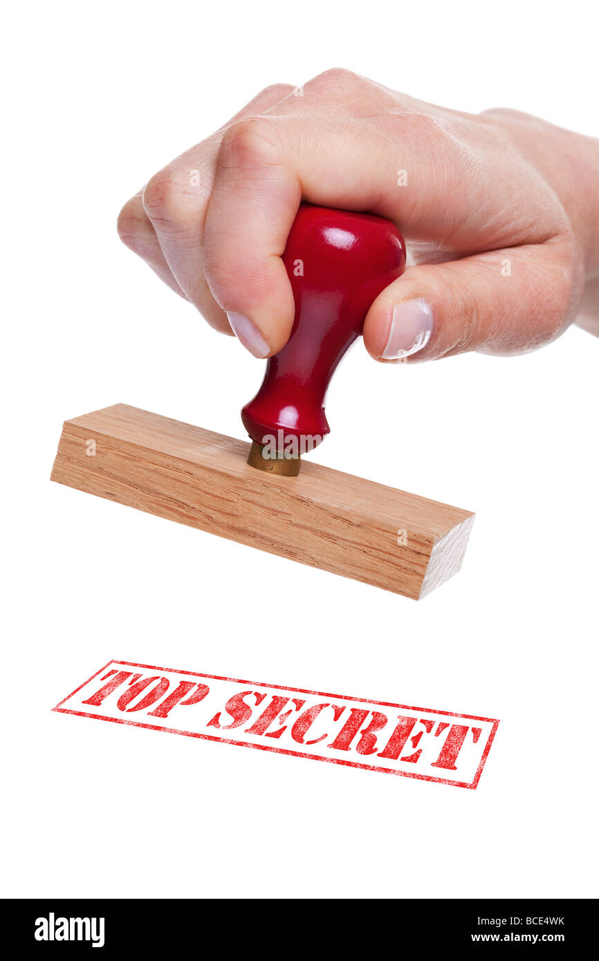 Hand holding a rubber stamp with the words Top Secret Stock Photo