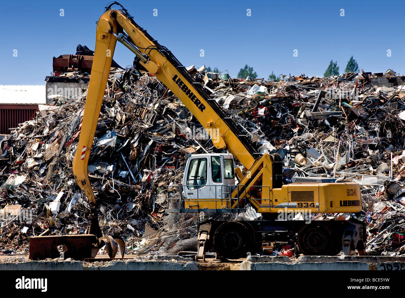 Mechanical digger in front of a waste stack in Copenhagen harbour Stock Photo