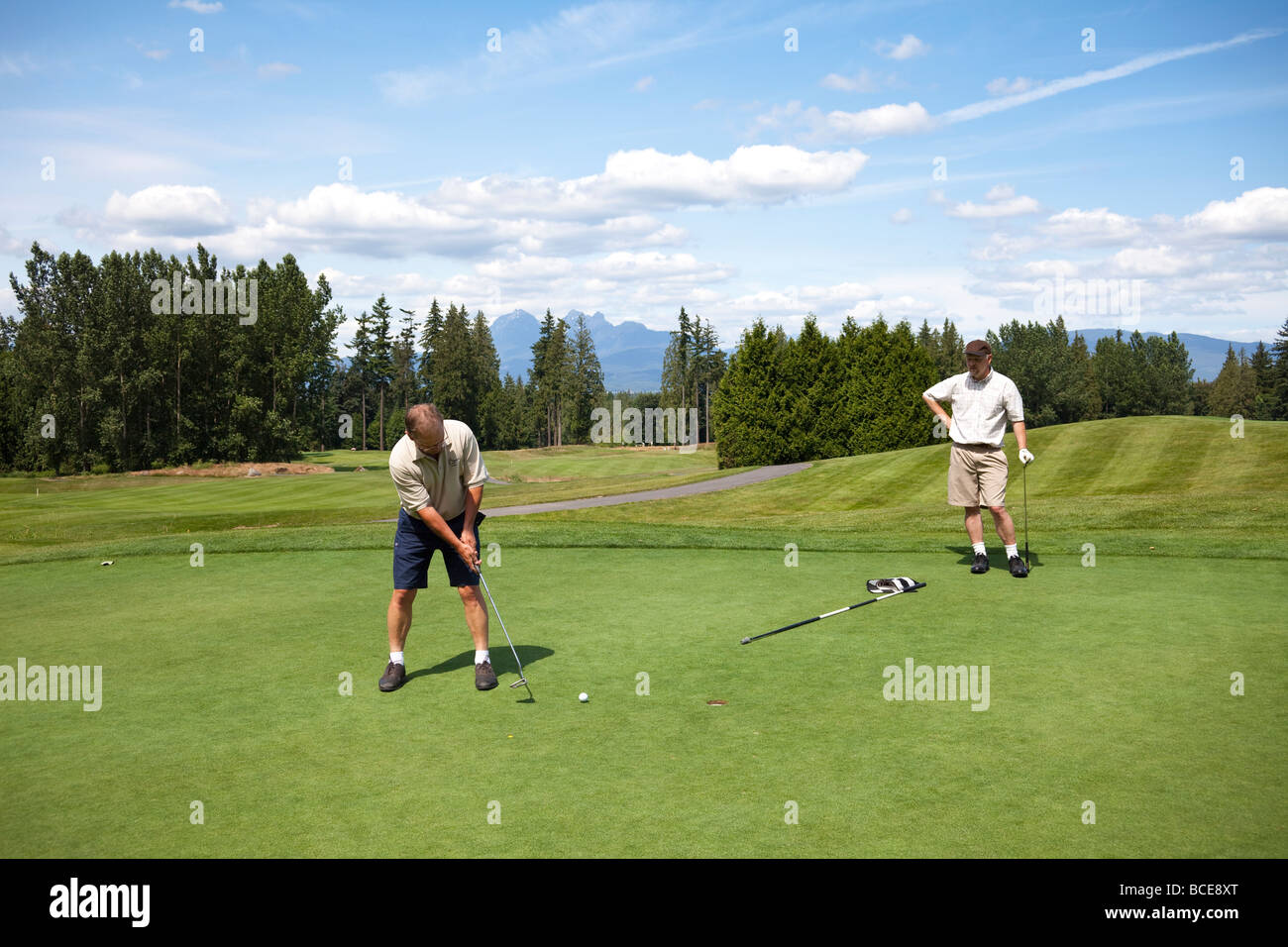 two golfers on putting green at eighth hole Redwood Golf Club, Langley, BC, Canada Stock Photo