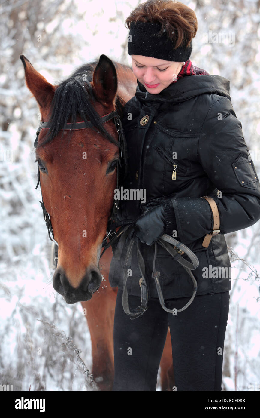 Young lady riding western style on back horse in winter Stock Photo